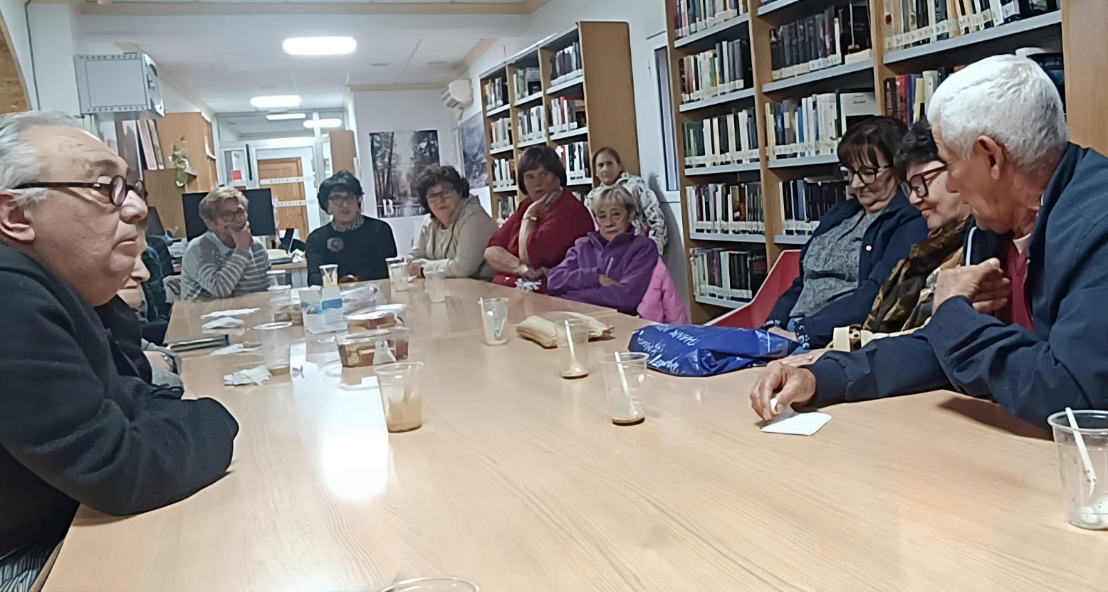 Asistentes al Café Solidario en la Biblioteca de Bienservida.